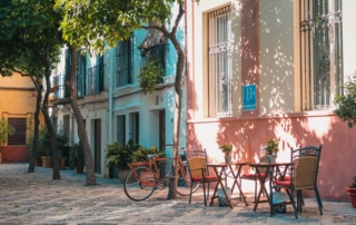 Trees, tables, chairs, bike on Sevilla street.